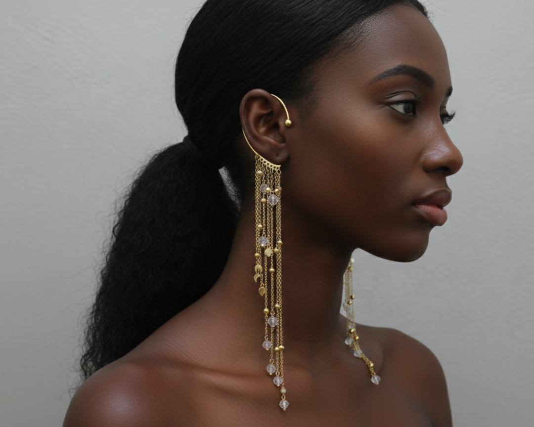 Handmade long gold statement earrings with delicate chains and crystal accents styled on a model