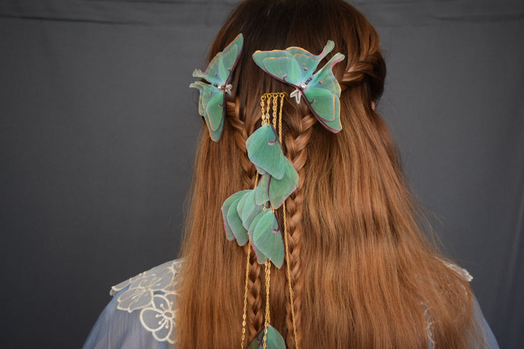 Handmade silk moth hair accessory with layered organza wings, gold chains, and cascading details styled in braided hair