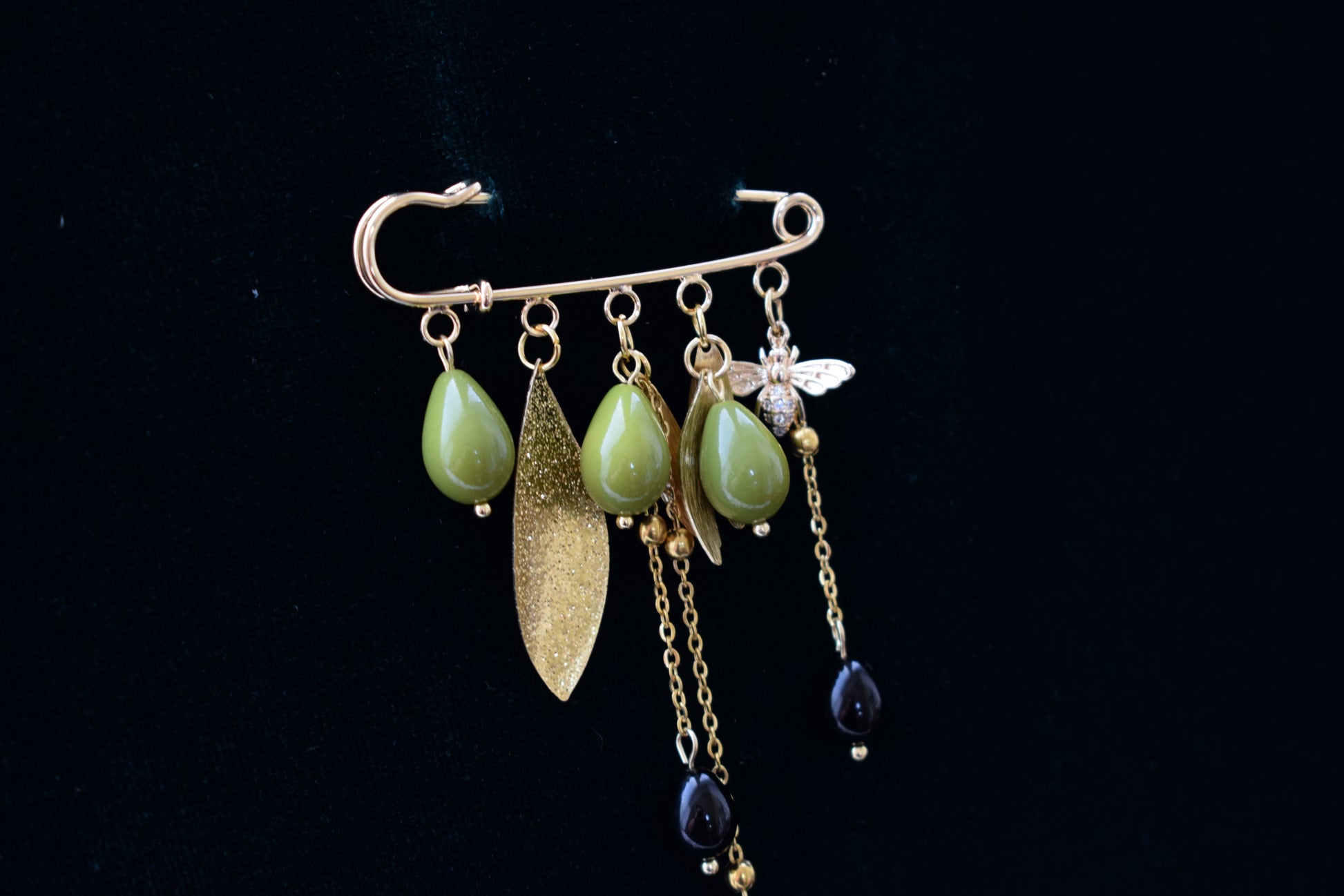 Decorative brooch with green beads, gold leaf