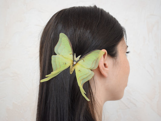 Large olive silk luna moth hair clip styled in hair with layered organza wings