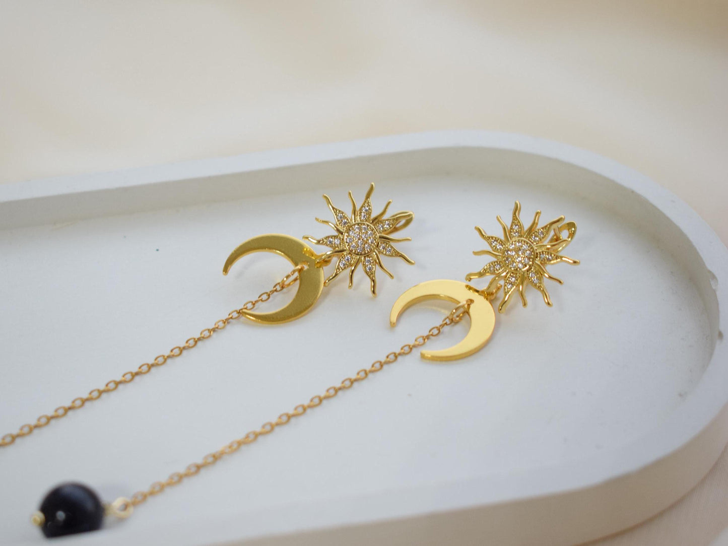 Close-up of handmade sun and moon earrings