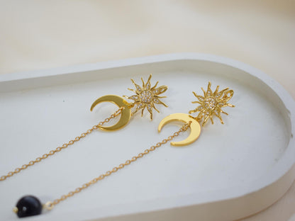 Close-up of handmade sun and moon earrings
