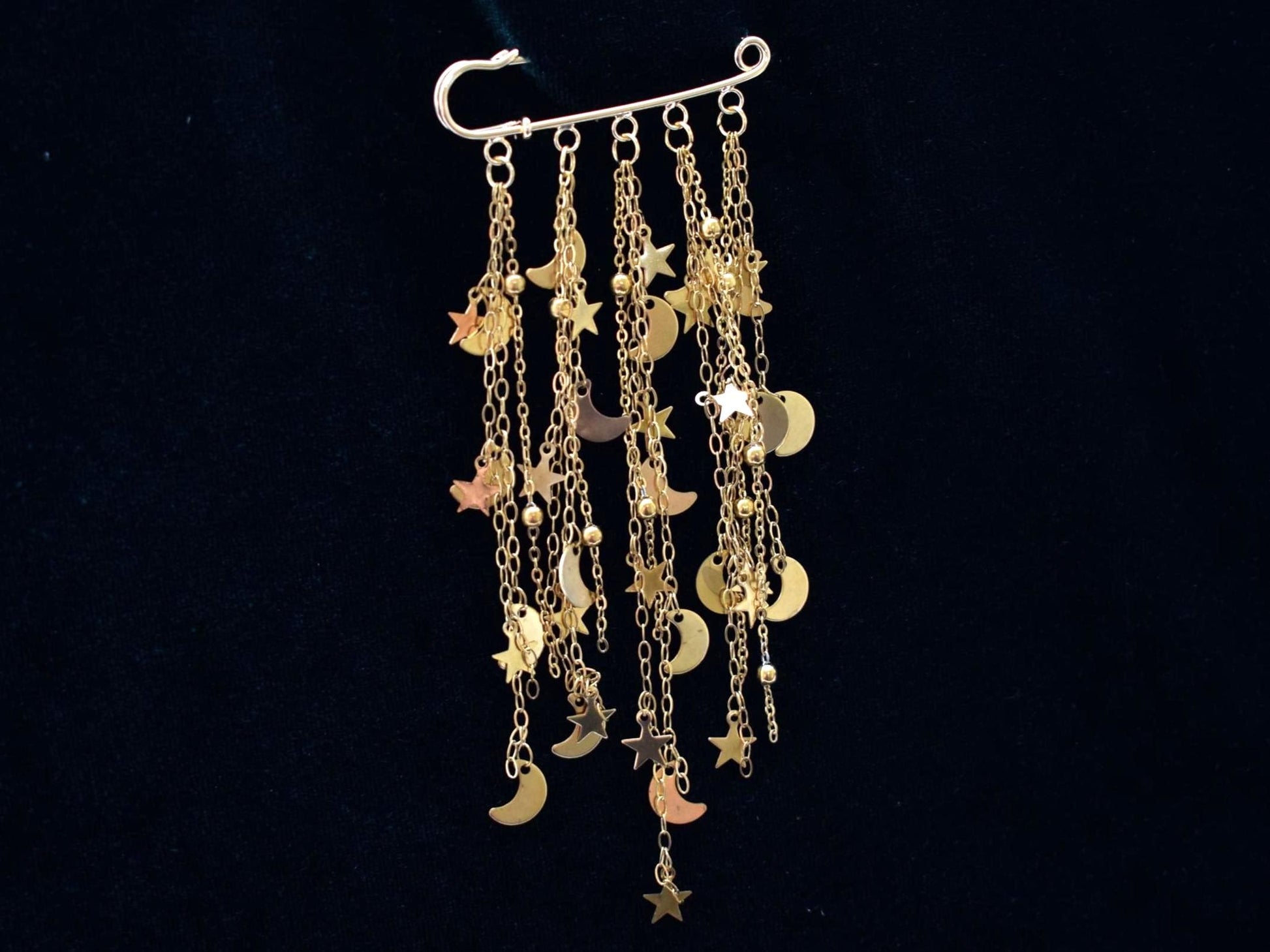Gold charm brooch with stars and moons 