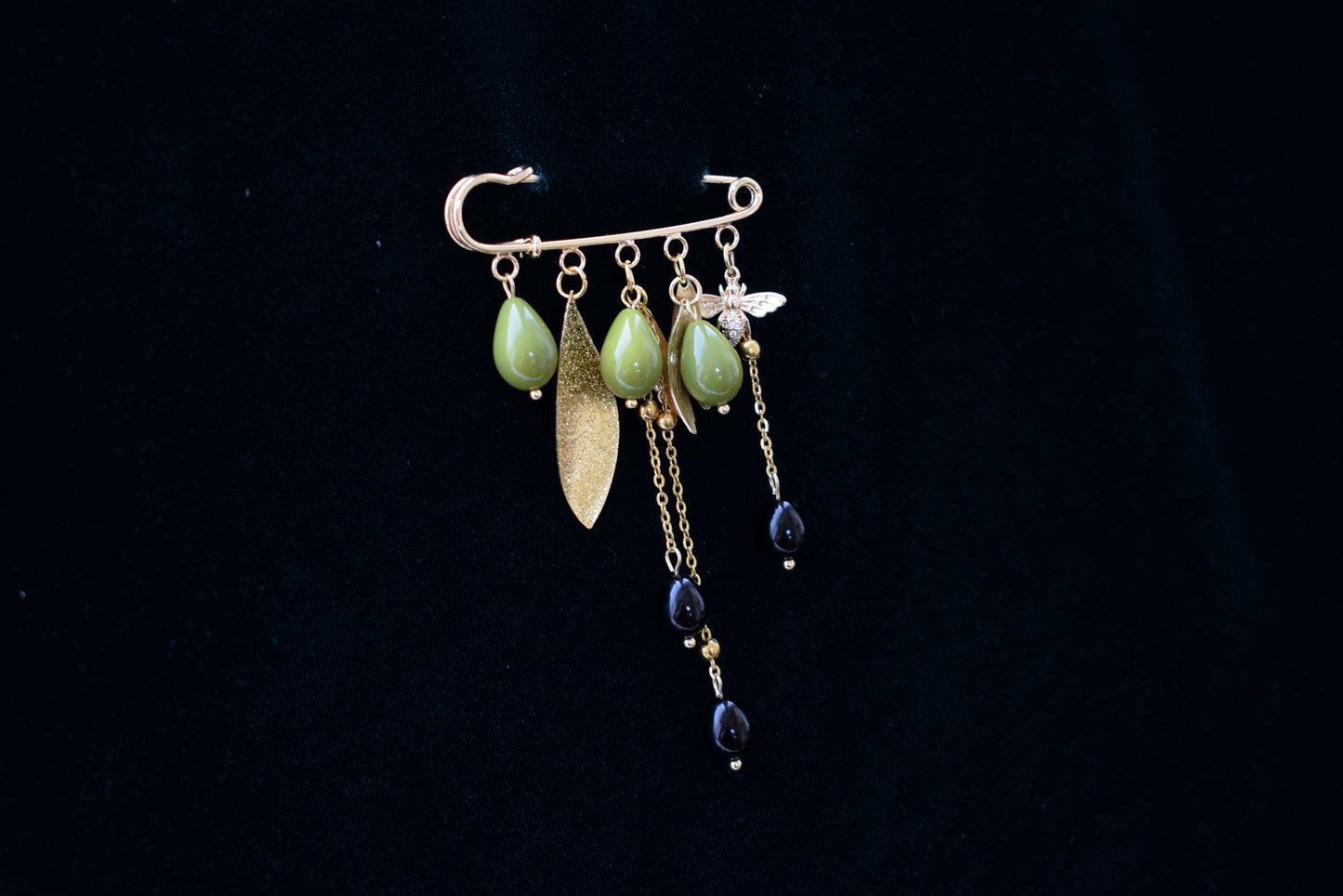 Nature-inspired gold brooch with green glass beads