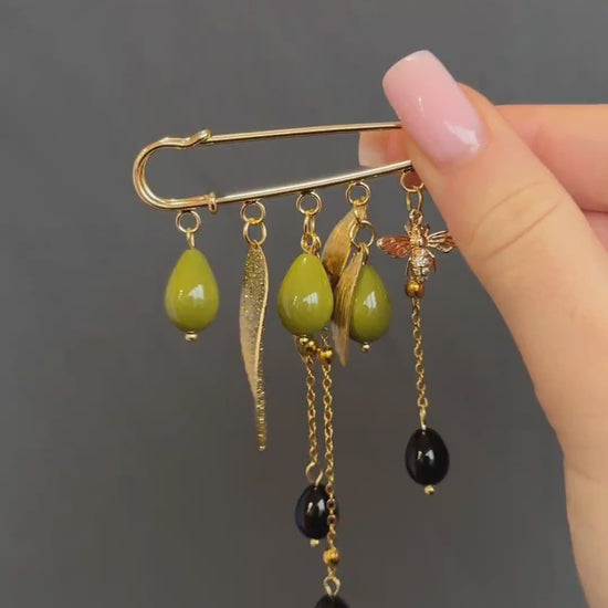 Nature-inspired gold brooch with green glass beads